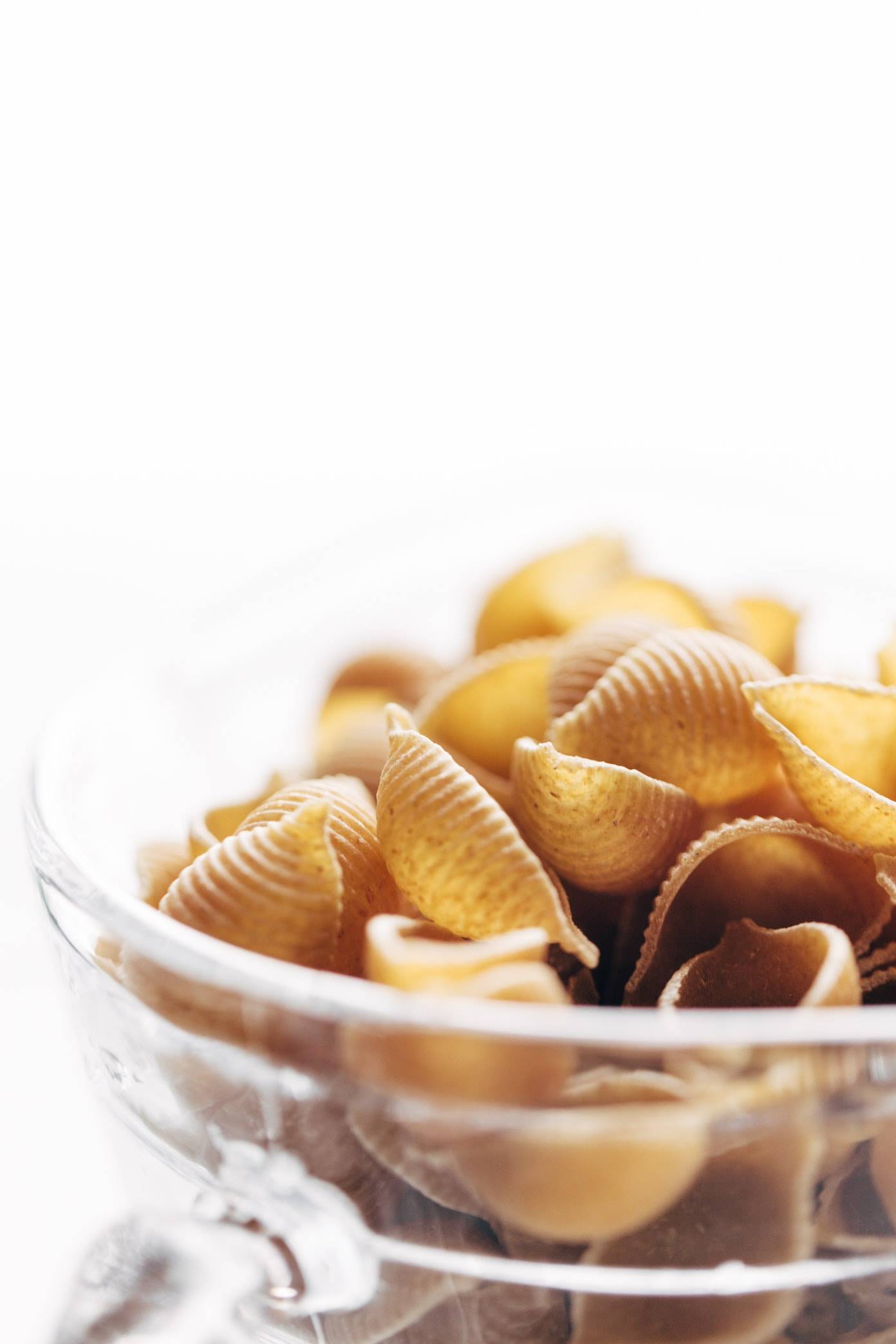 Dry pasta noodles in a clear bowl.