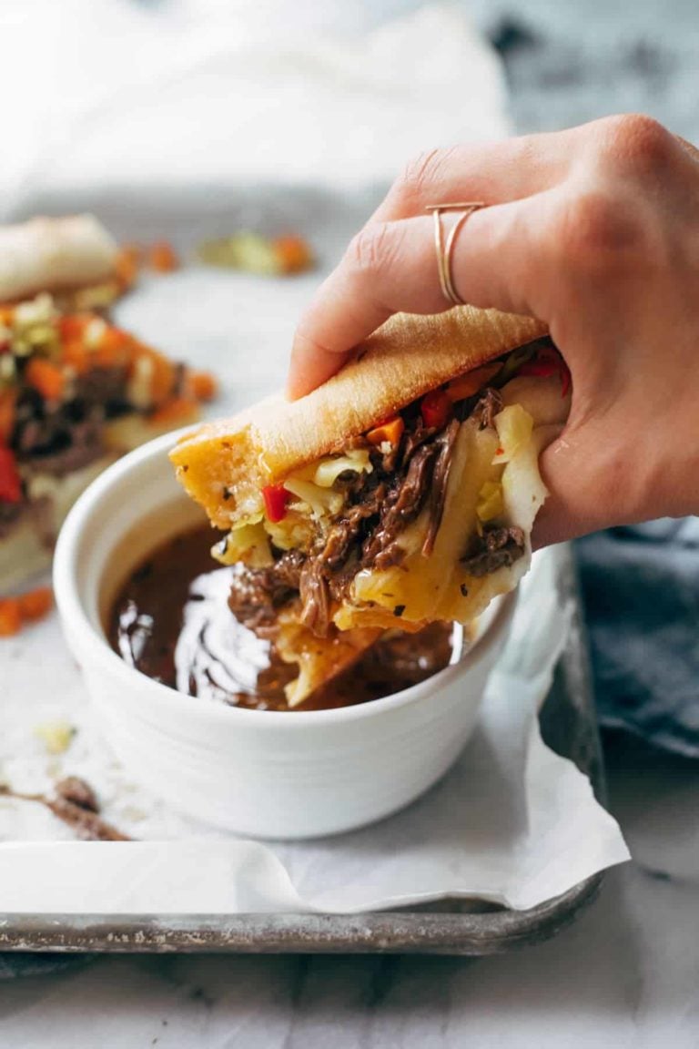 Instant Pot Italian Beef sandwich being dipped in a sauce.