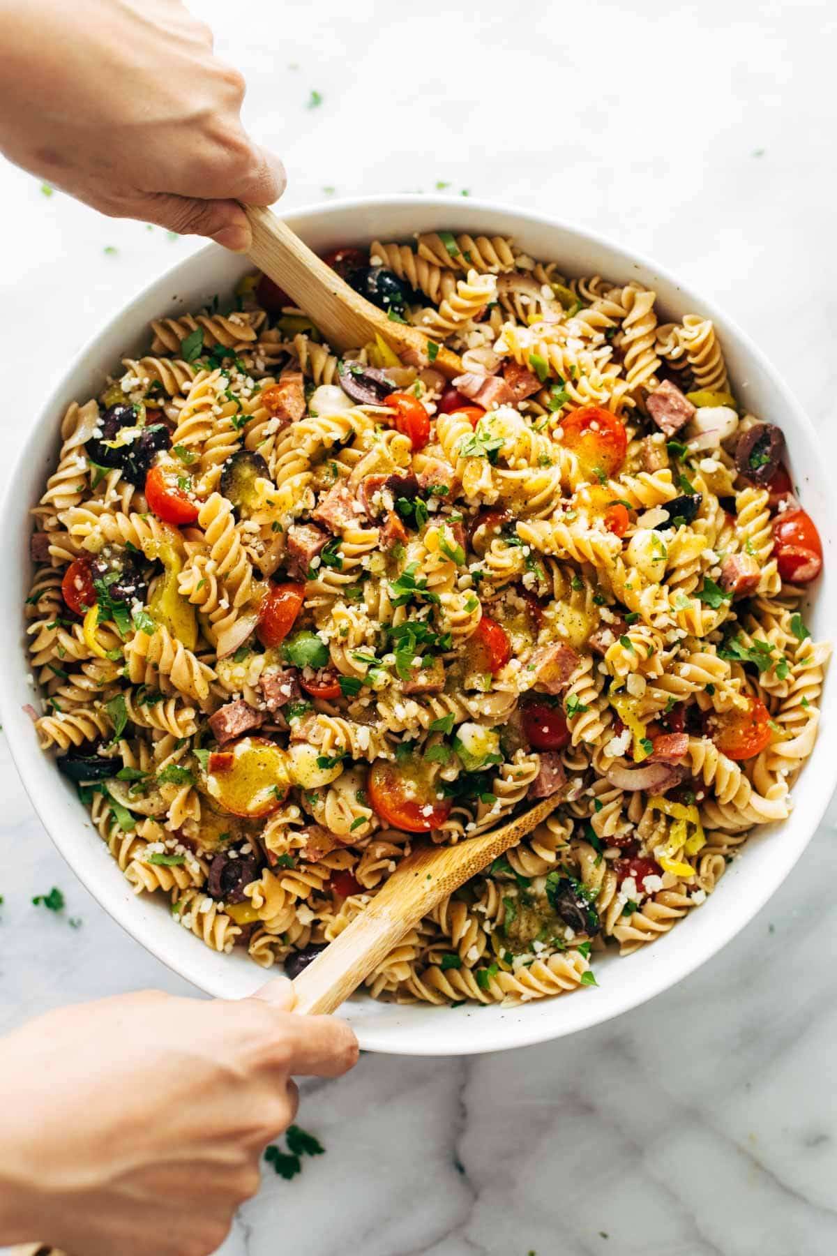 Salade de pâtes mélangée avec des cuillères.