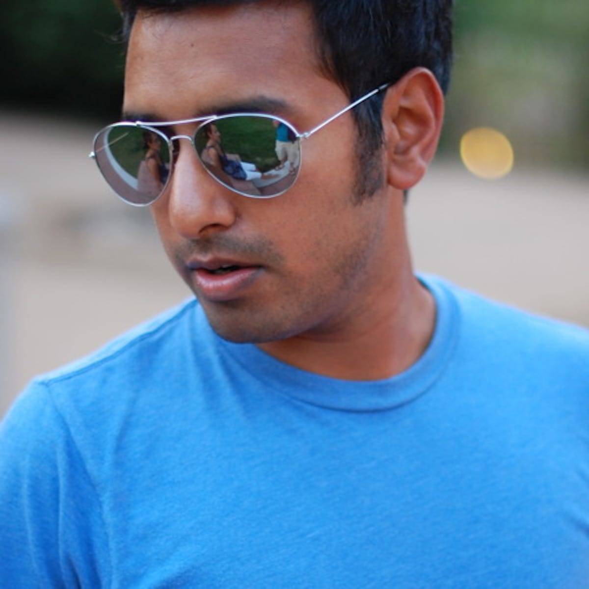Man wearing sunglasses and a blue shirt.