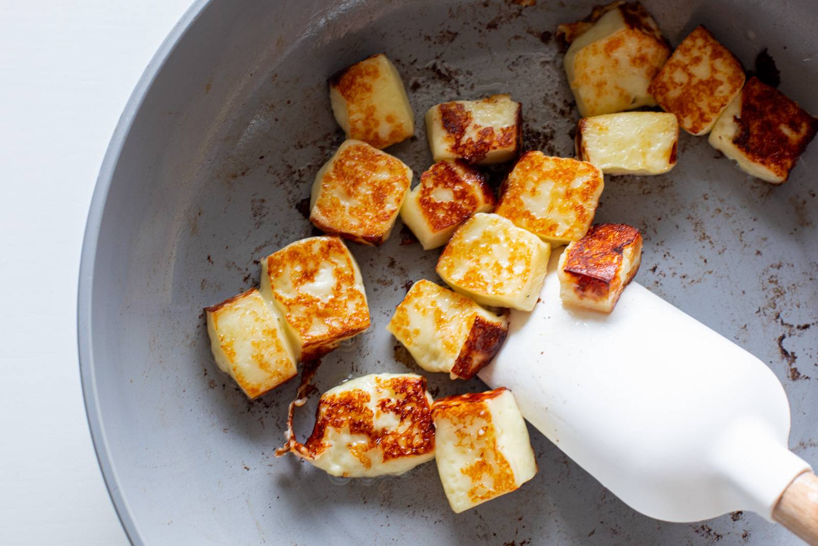 Bread cubes fried up in a pan.