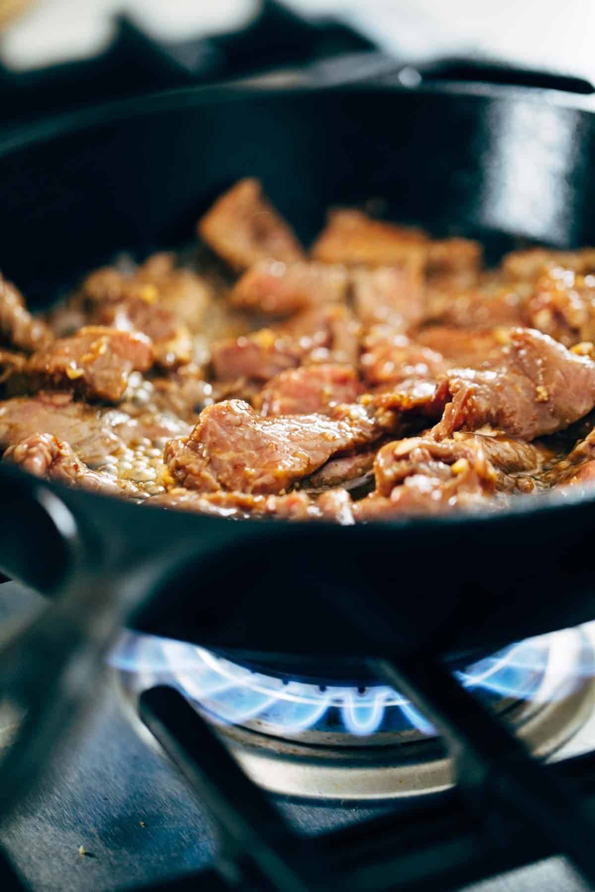 Korean BBQ Steak Bowls! Featuring Korean BBQ steak, bell peppers, scallions, greens, wonton strips, a spicy sesame ginger dressing. | pinchofyum.com