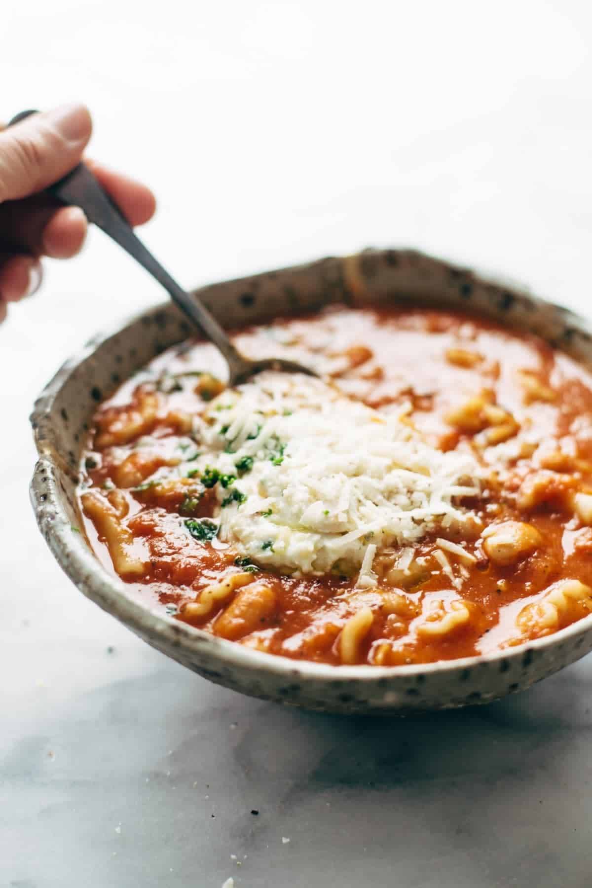 Roasted Garlic and White Bean Lasagna Soup in a bowl with a spoon.