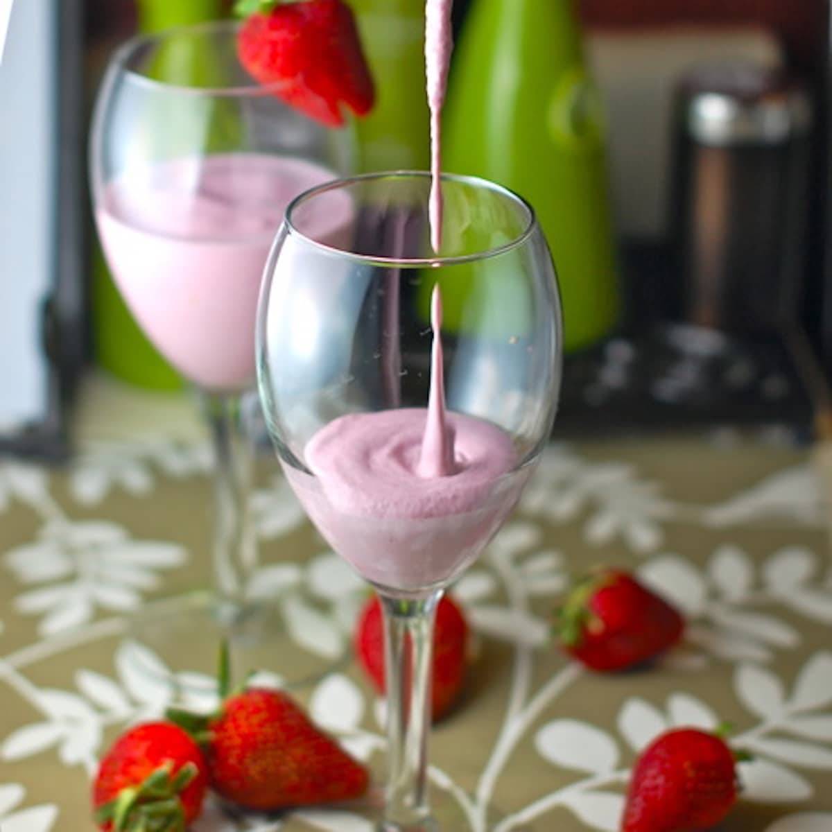 Lemon berry smoothie in a glass with strawberries.