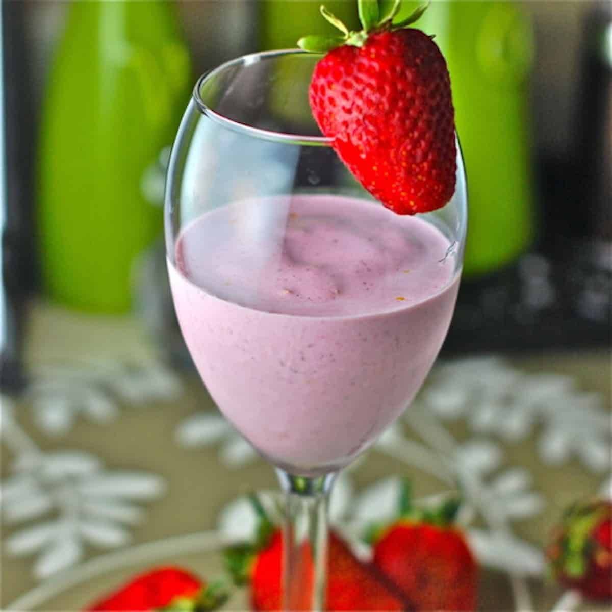 Lemon berry smoothie in a glass with a strawberry.