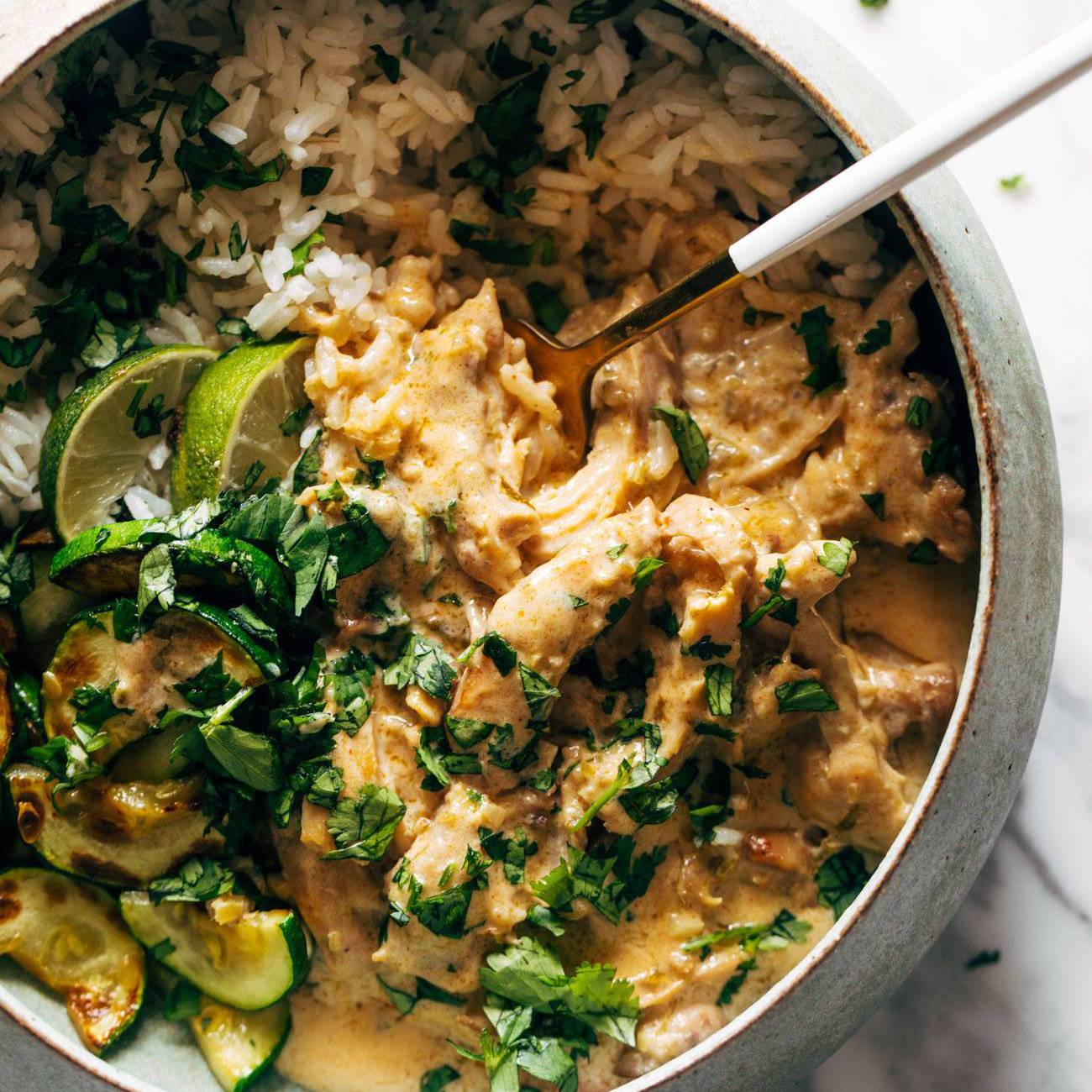 Lemongrass chicken in a bowl with rice and zucchini.