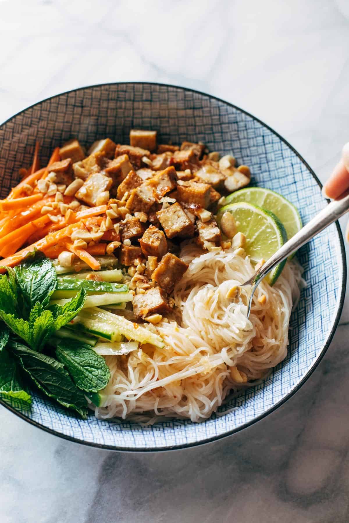 Vermicelli salad in a bowl with tofu and herbs.