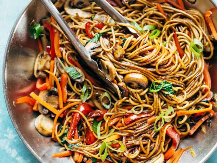 Lo Mein in pan with tongs.