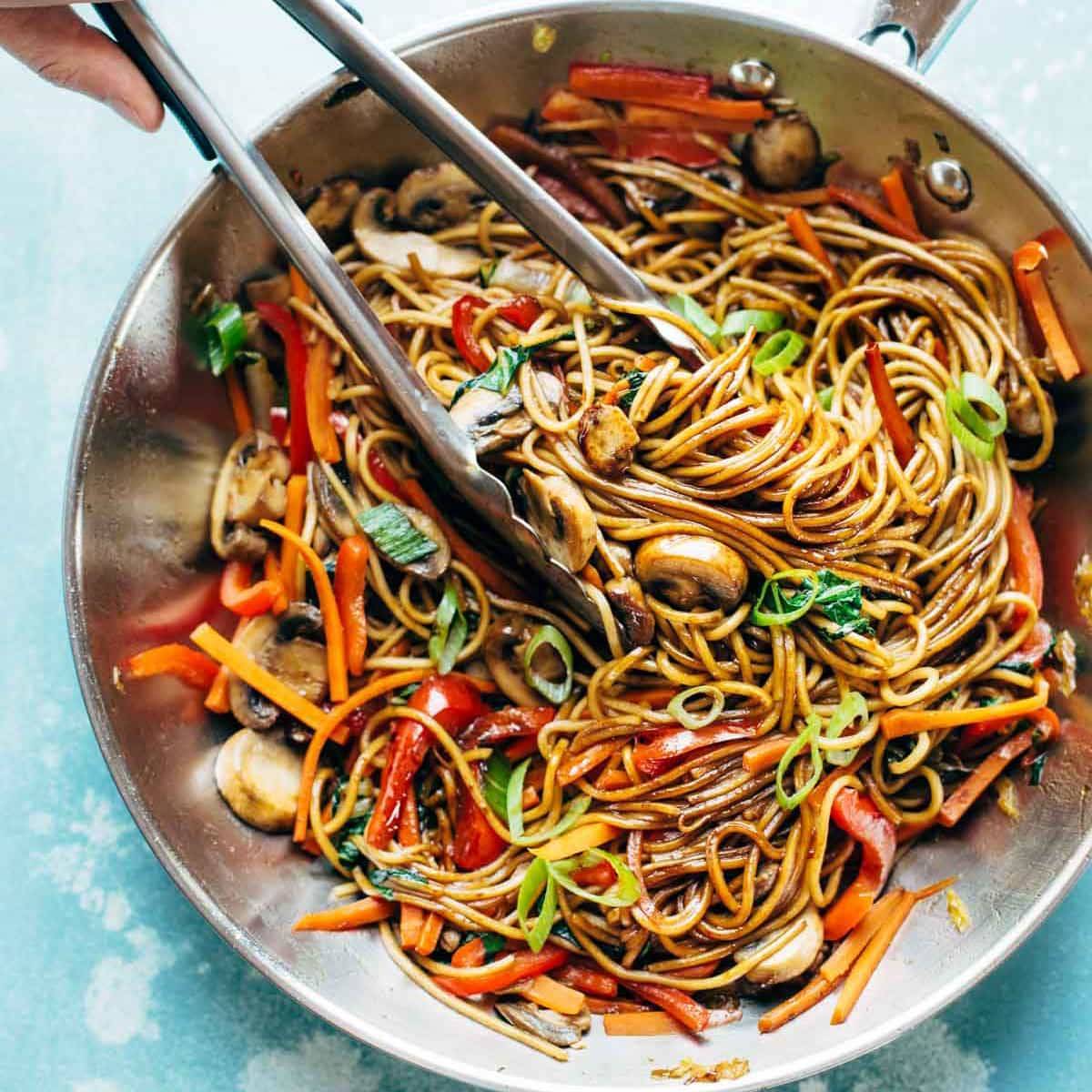 Lo Mein in pan with tongs.