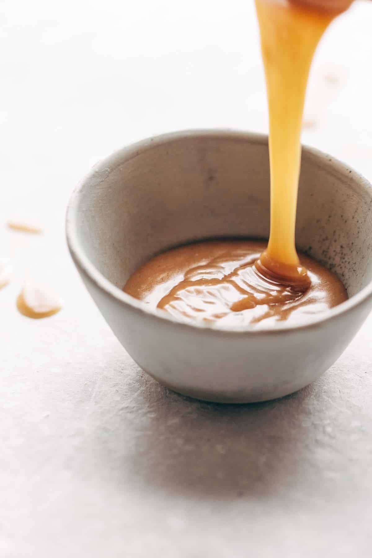 Magic Vegan Caramel Sauce in a dish with a drizzle.