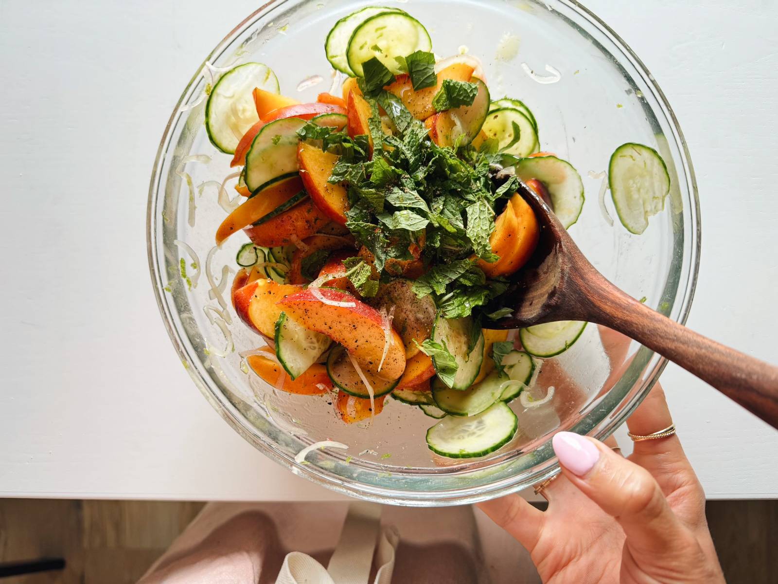 Peach salad in a bowl sprinkled with mint.