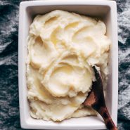 Mashed Potatoes in serving dish with wooden spoon.