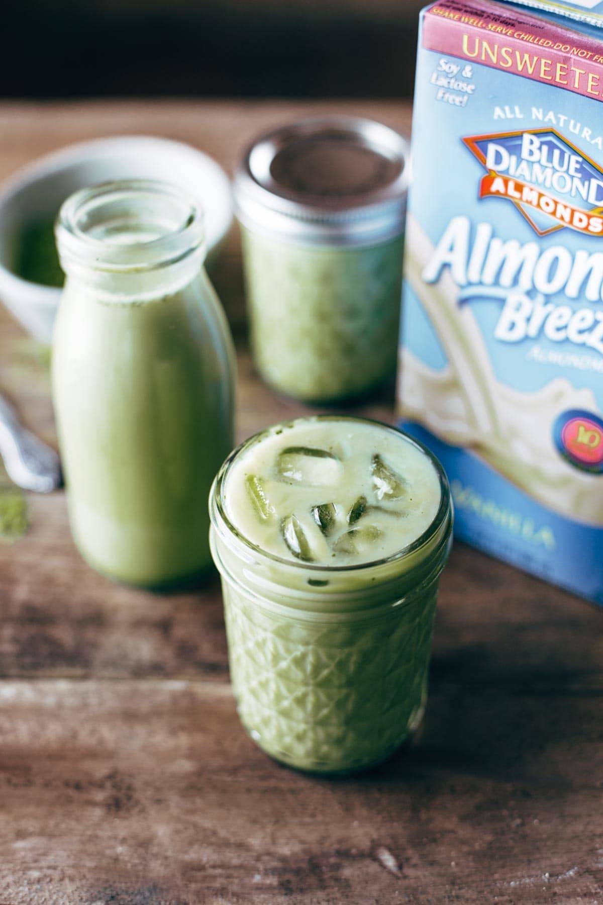 Iced matcha in a jar with ice and a box of Blue Diamond Almond Breeze almondmilk next to it. 