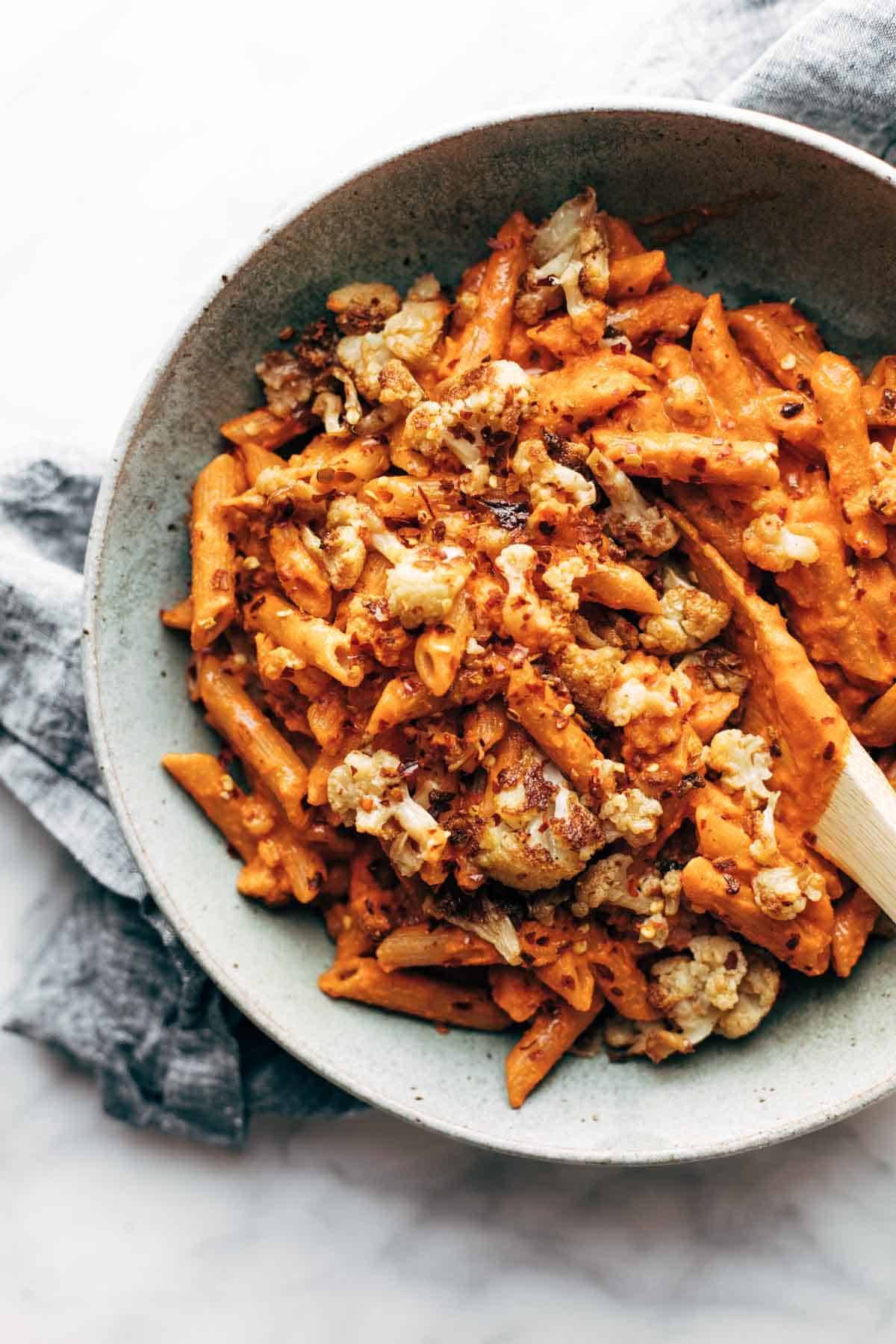Red Pepper Cashew Pasta with Roasted Cauliflower on a grey plate.