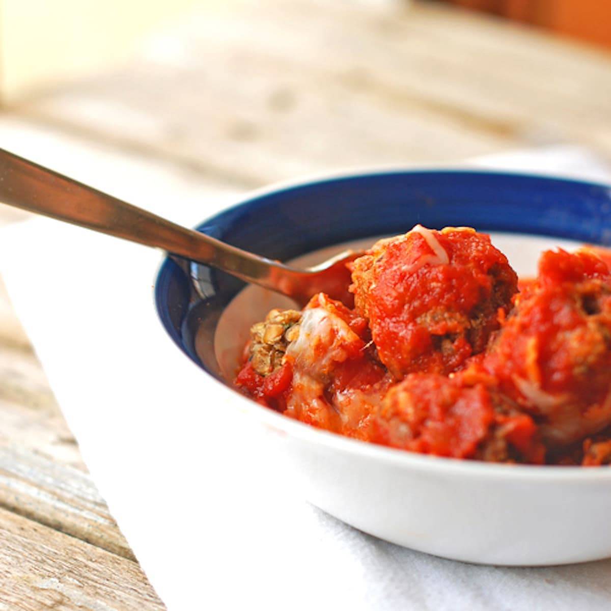 Meatless Meatballs with lentils and wild rice, and topped with marinara sauce and melted cheese. 