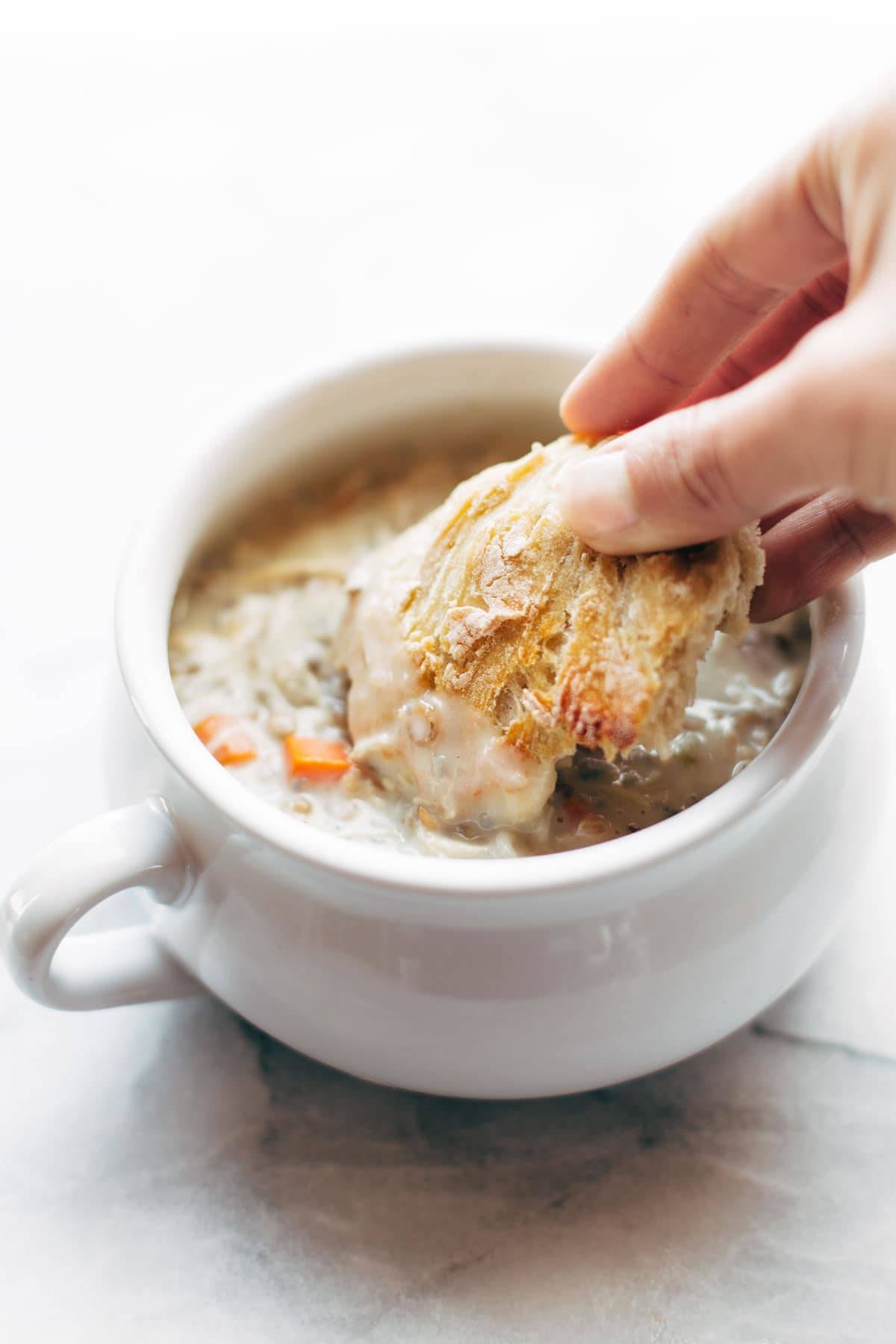 Bread being dunked in soup. 