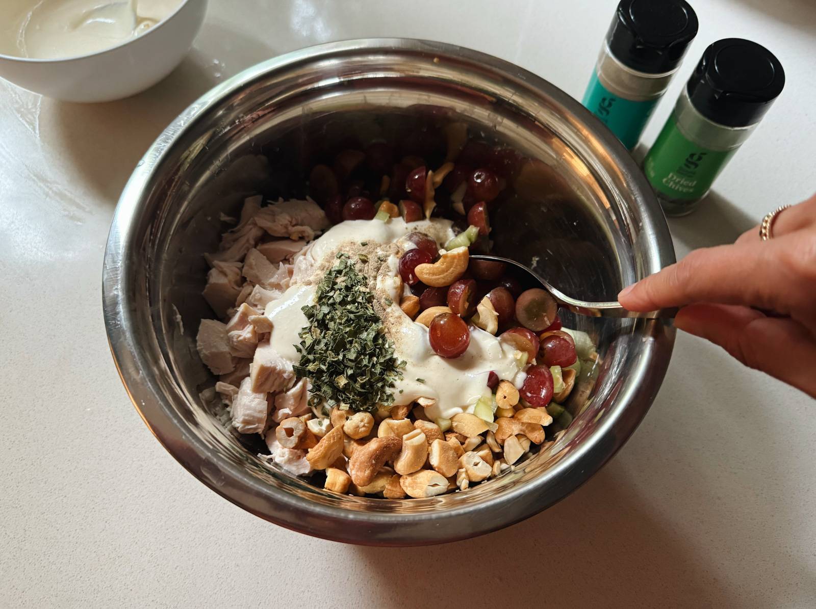 Mixing chicken salad ingredients in a large bowl.