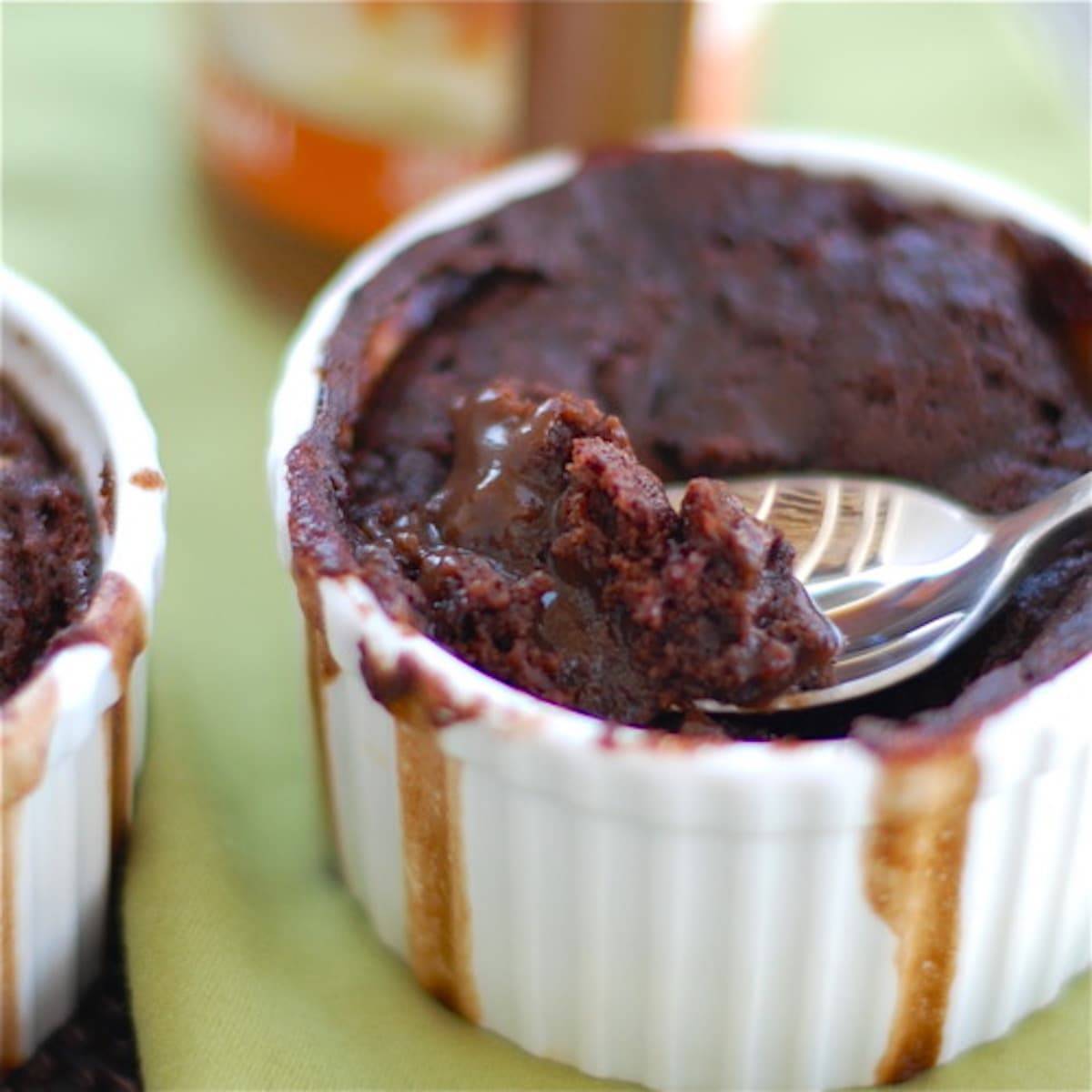 Molten Chocolate cake in a white dish with a spoon.