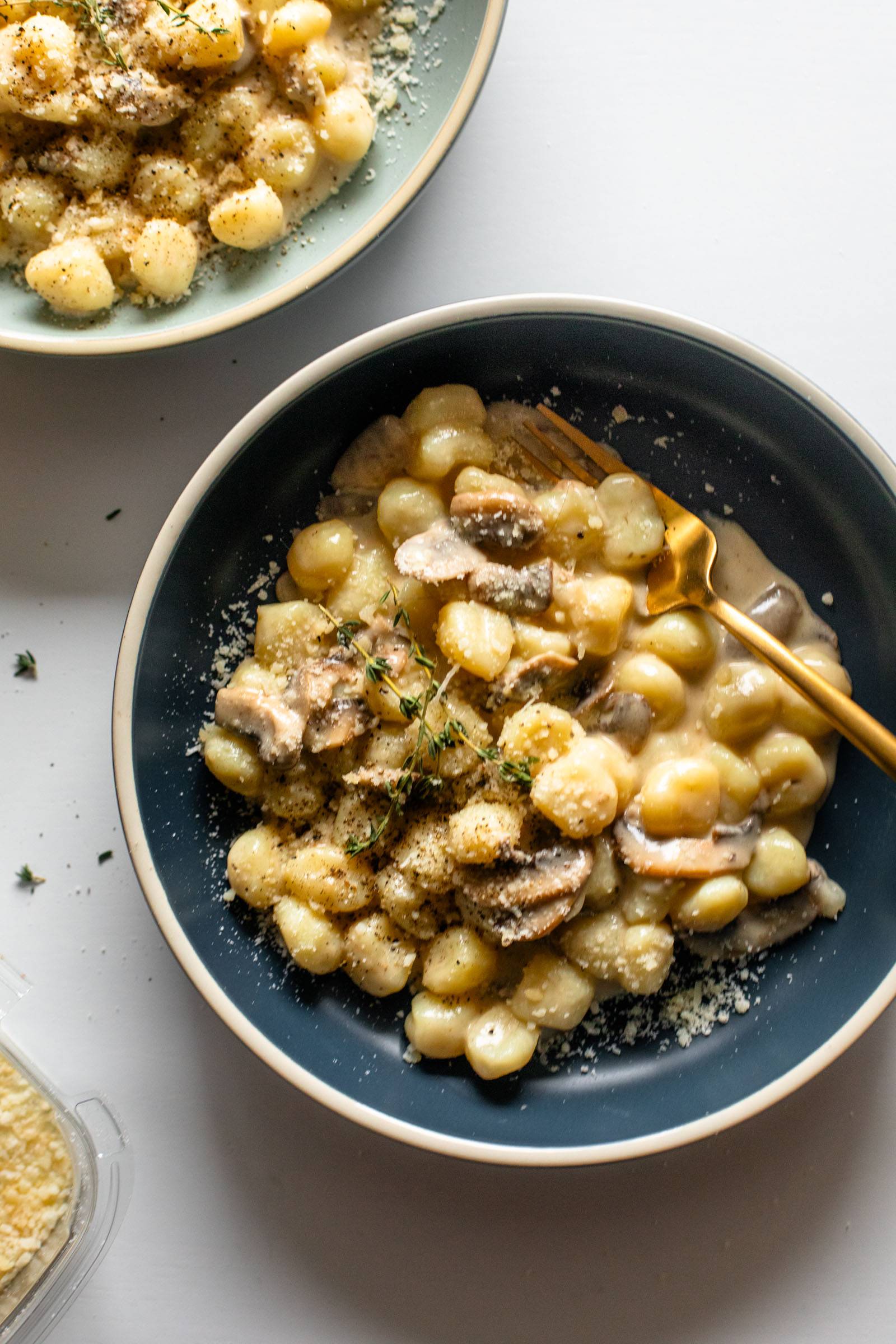 Gnocchi in a creamy mushroom sauce in a bowl with a fork.