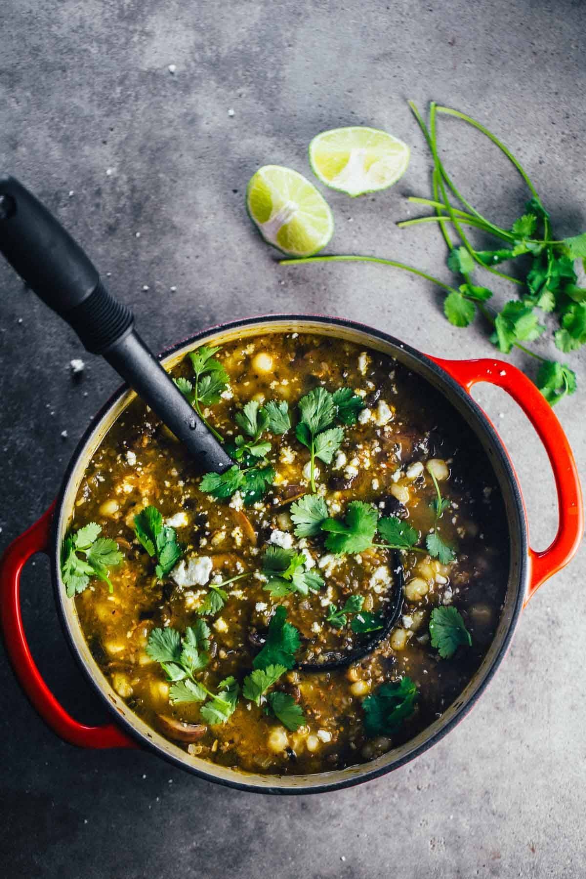 Mushroom Poblano Posole Verde in a dutch oven with a spoon.