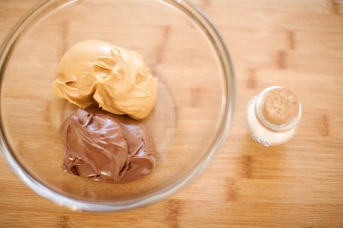 Nutella and peanut butter in a glass mixing bowl.