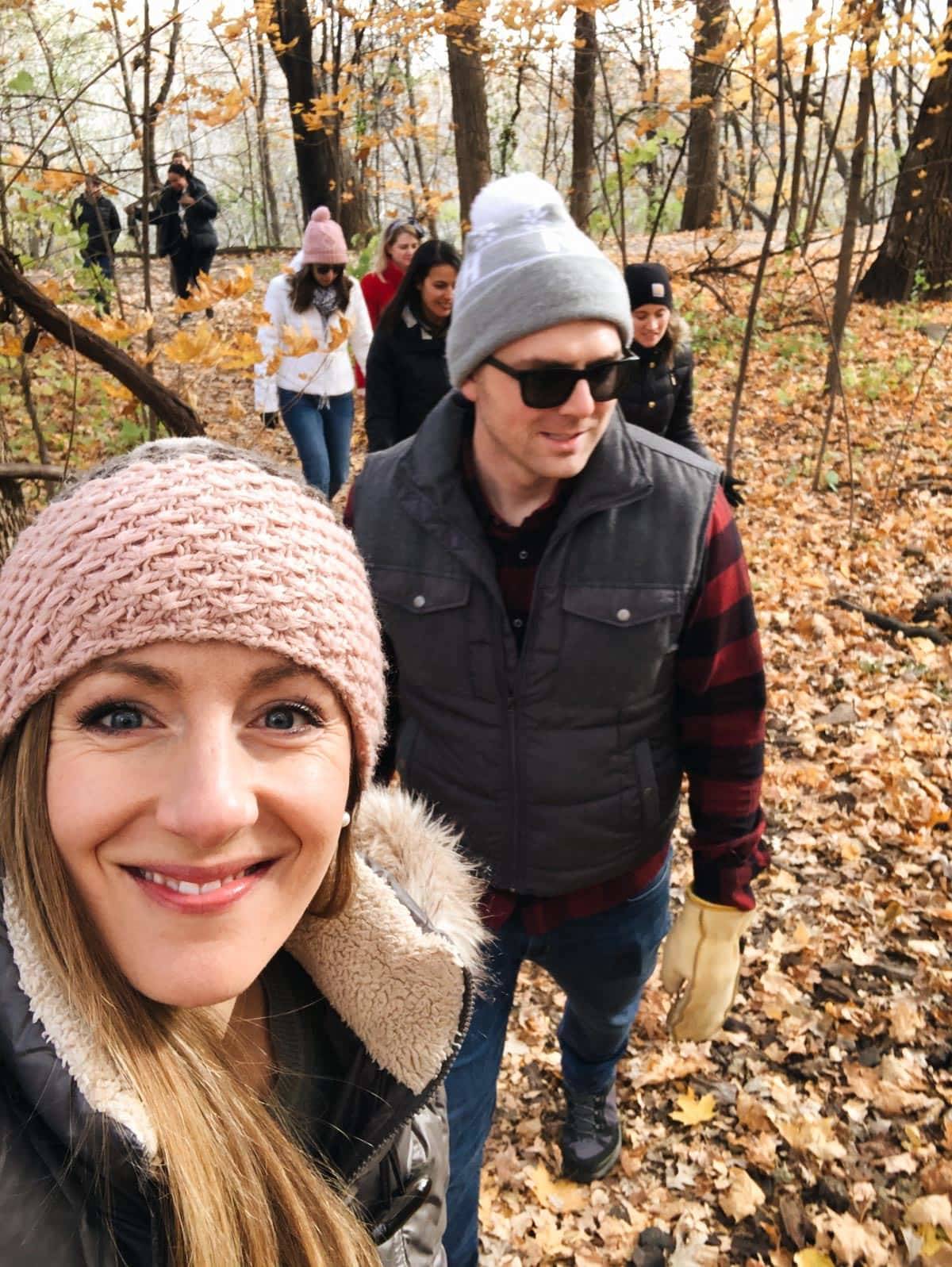 People wearing beanies hiking in the woods.