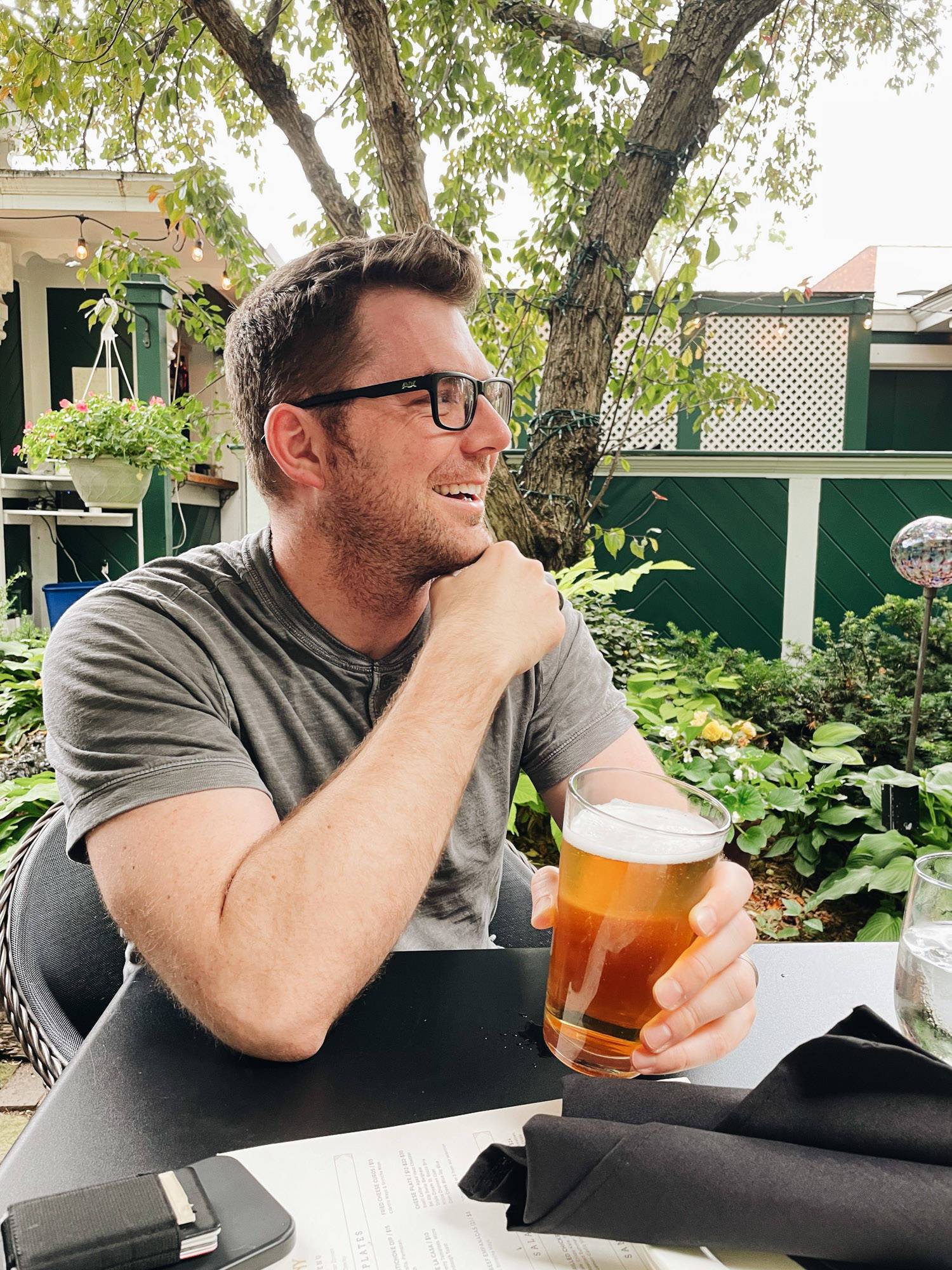 Man holding a beer and smiling. 