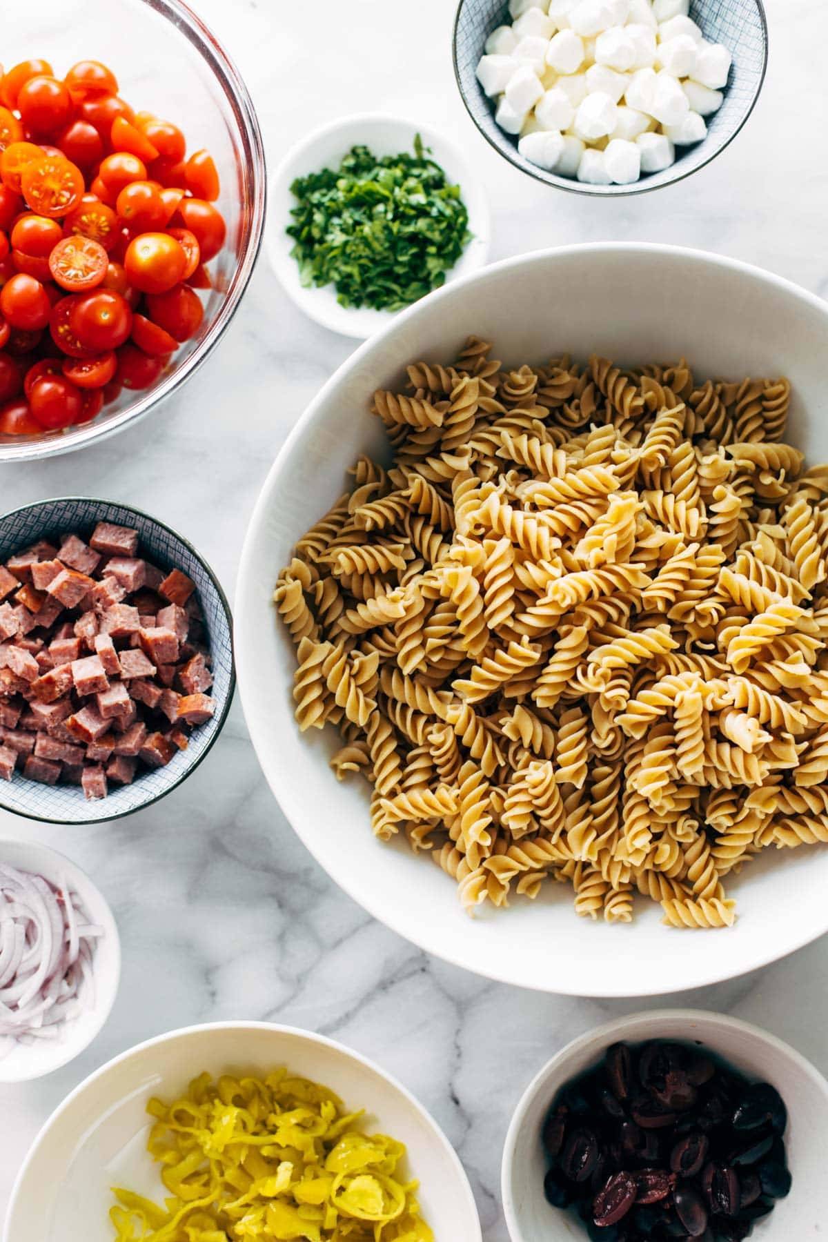 Ingredients for pasta salad in bowls.