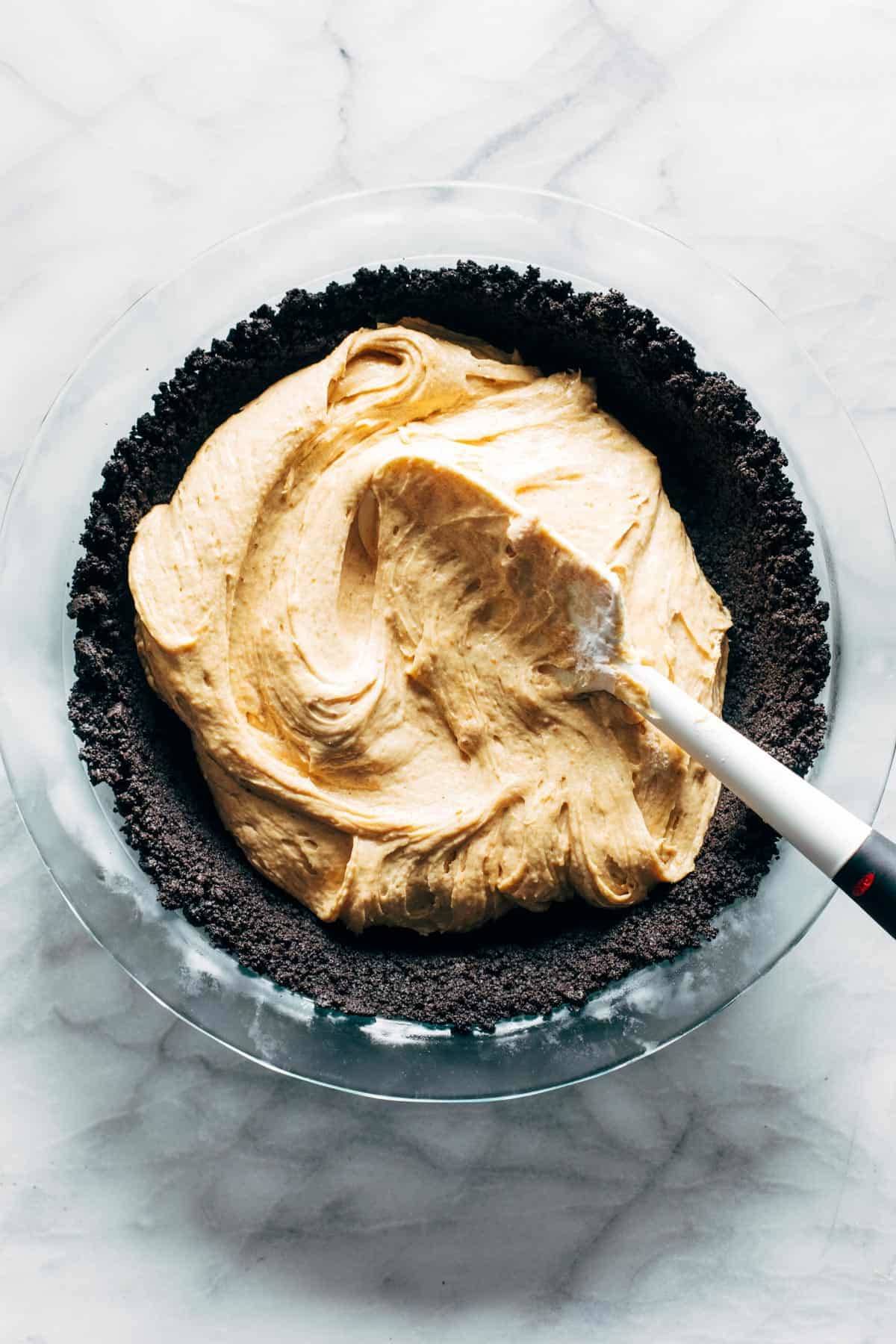 Spreading peanut butter filling in pie crust.