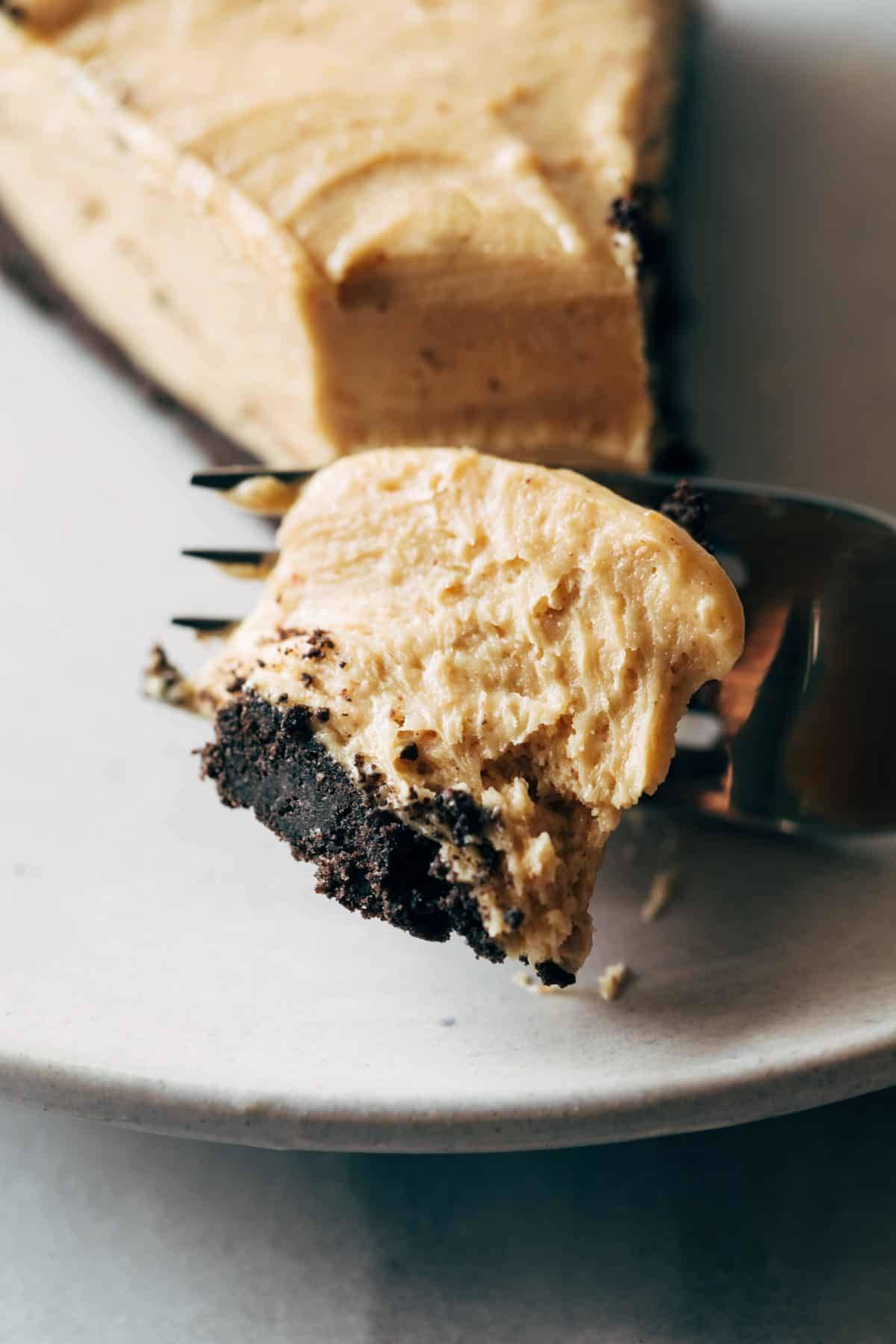 Taking a bite of peanut butter pie with fork.