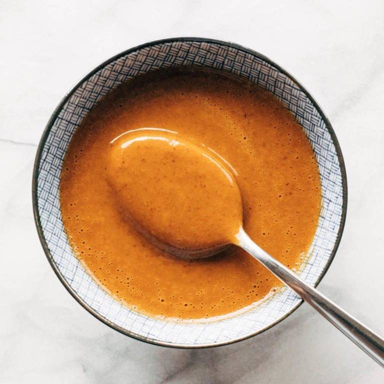 Peanut sauce in a bowl with a spoon.
