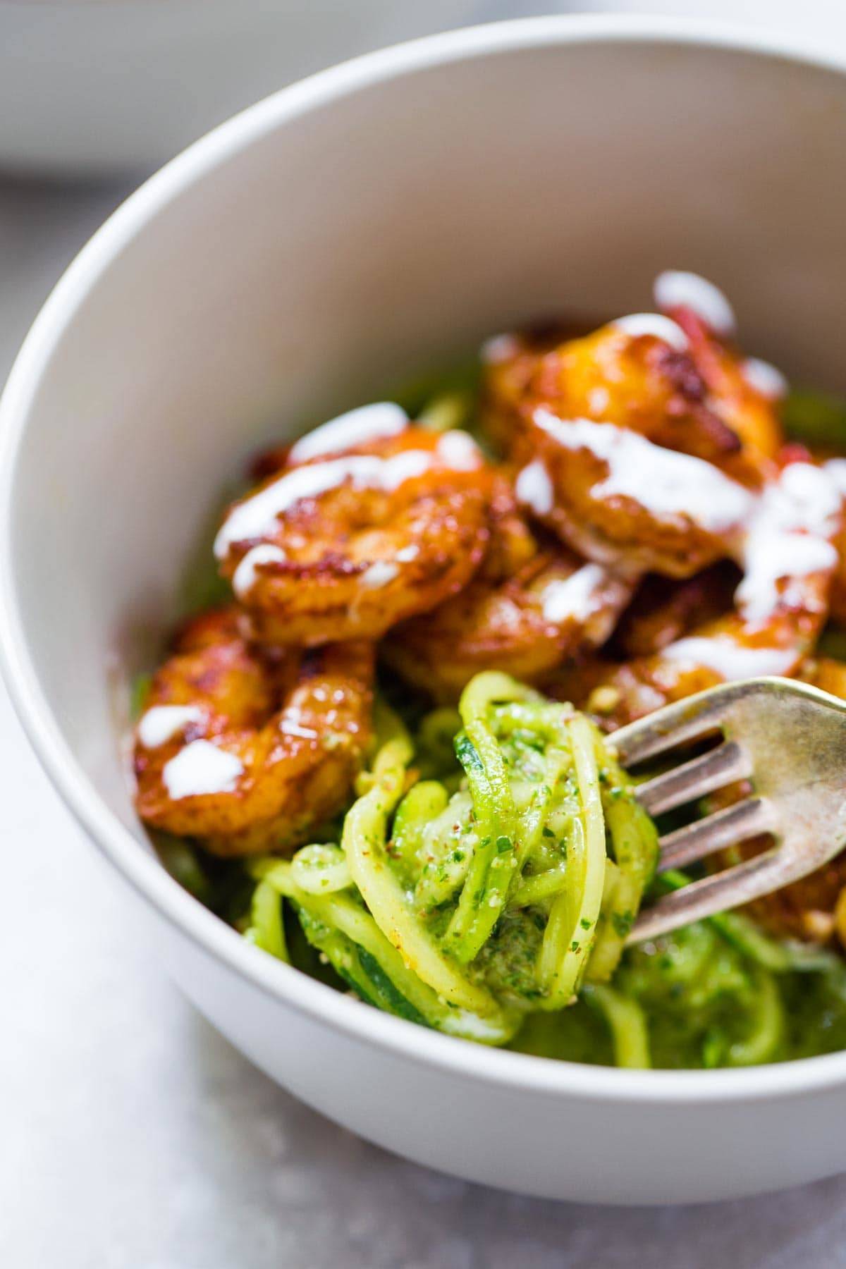 Shrimp with Pesto Noodles in a bowl with a fork.