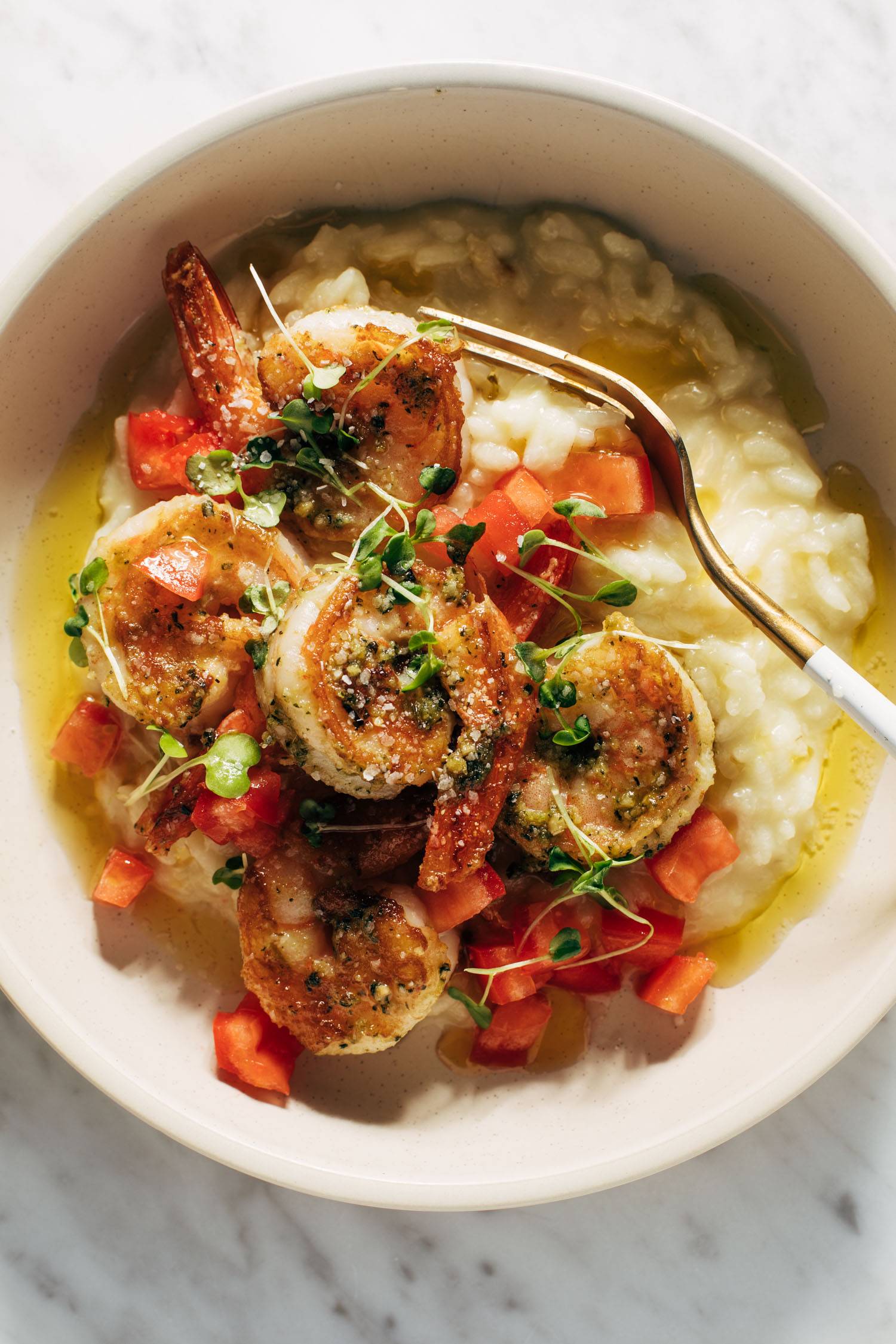 Pesto shrimp with risotto and a fork in a bowl