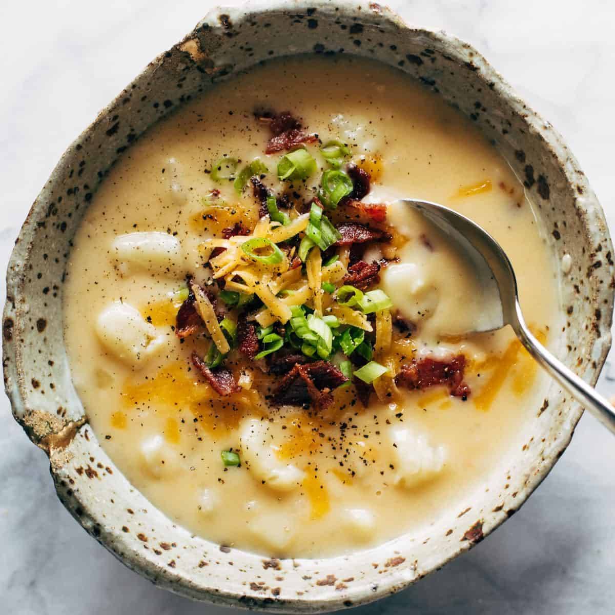 Instant Pot Loaded Potato Soup in a bowl with a spoon dipped in it.