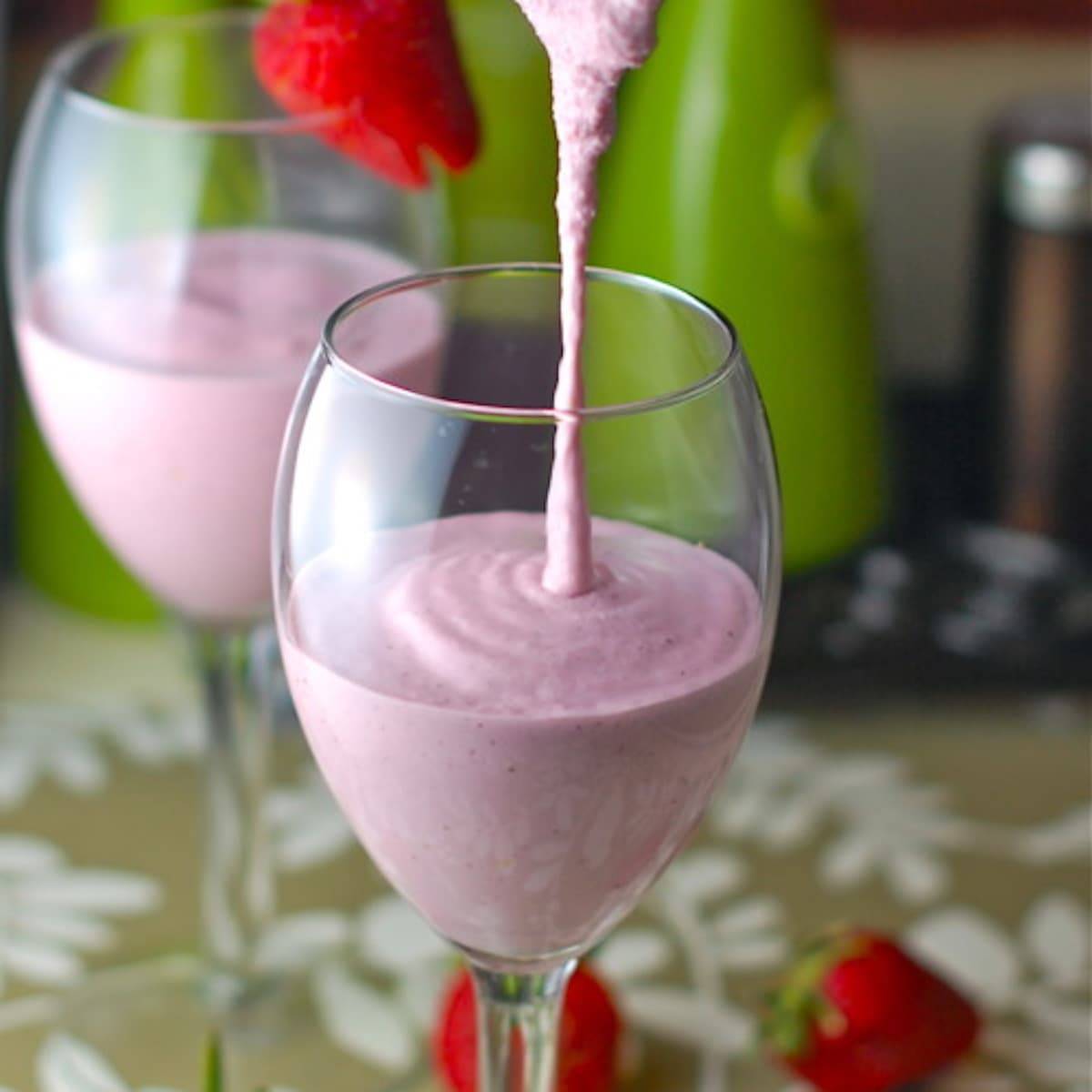 Lemon berry smoothie in a glass with smoothie drizzle.