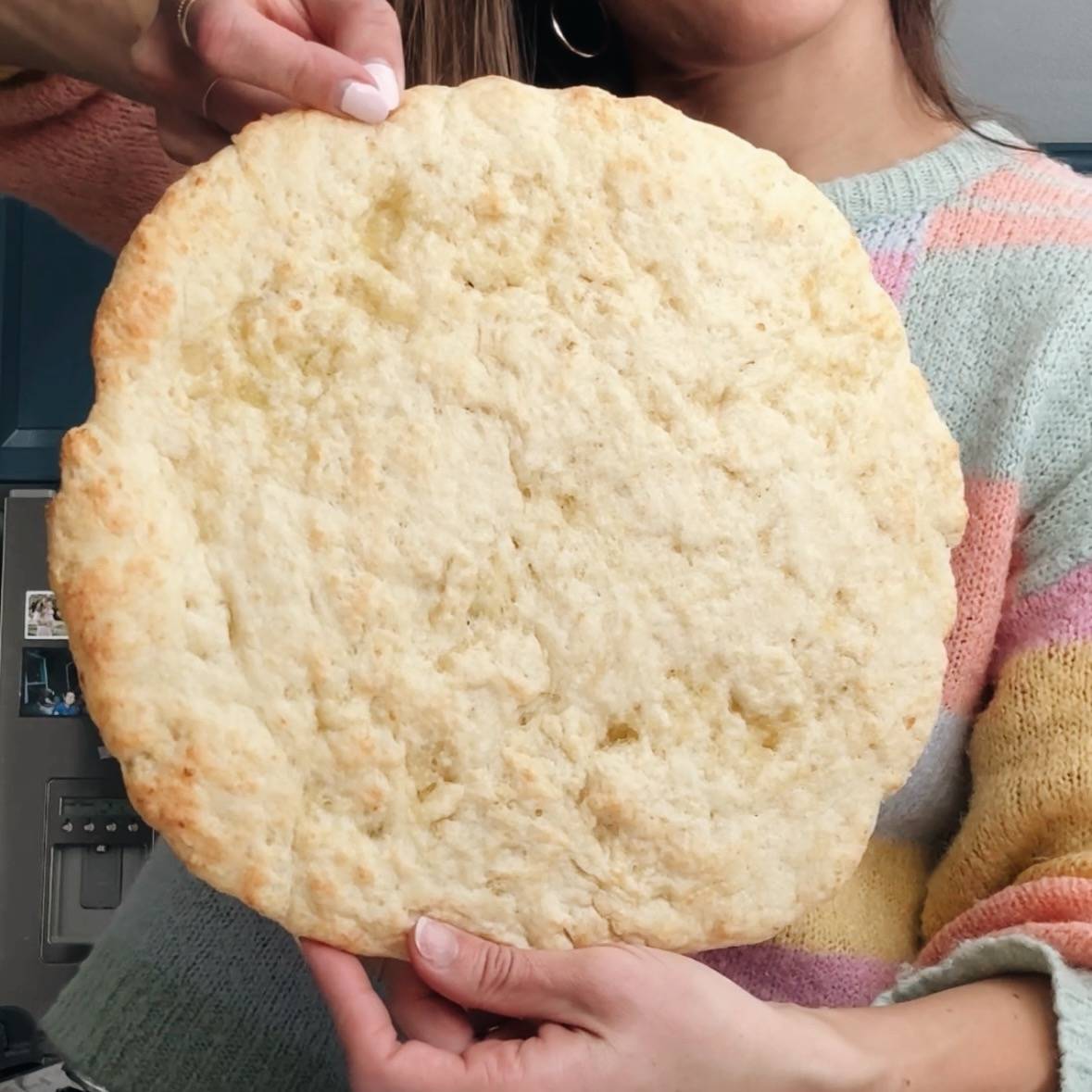 Lindsay holding a pre-baked pizza crust.