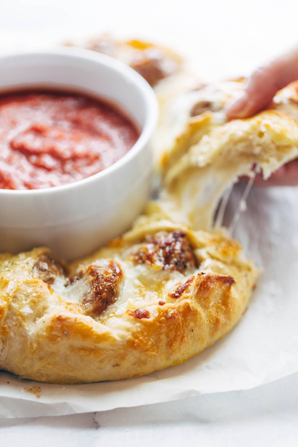 Cheesy Meatball Pull-Apart Pizza Ring with a bowl of marinara sauce 