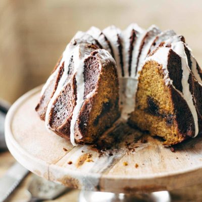 Pumpkin Bundt Cake on cake stand with glaze.