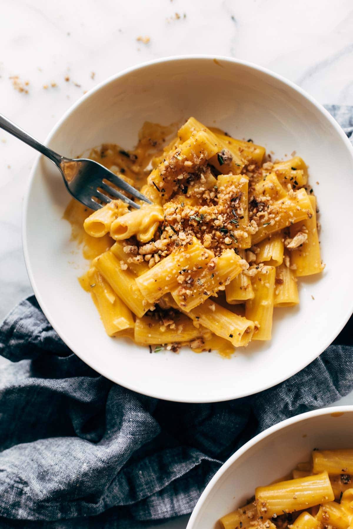 Pumpkin rigatoni in a bowl with walnut crispies.