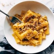 Pumpkin Rigatoni pasta dish with Walnut Crispies in a bowl with fork.