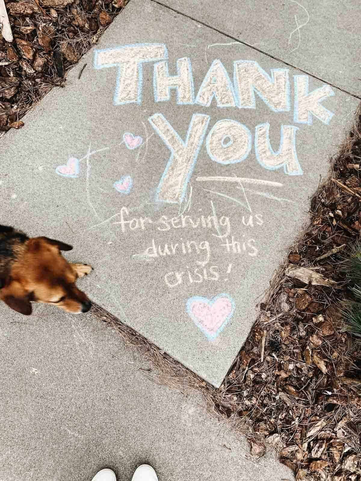 A dog walking next to a message on a tile that thanks people who served during Covid.