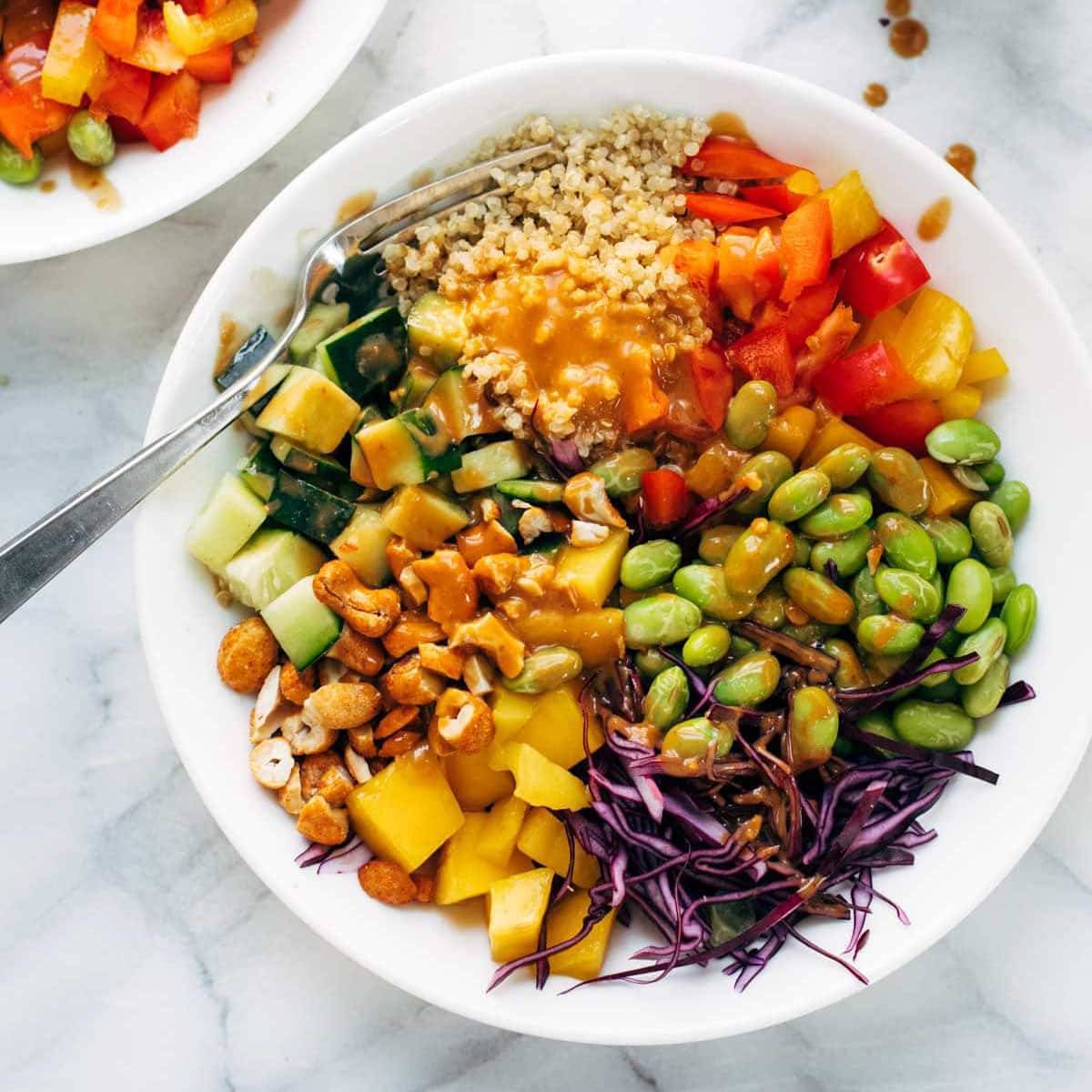 Quinoa salad with veggies in a bowl with a spoon.