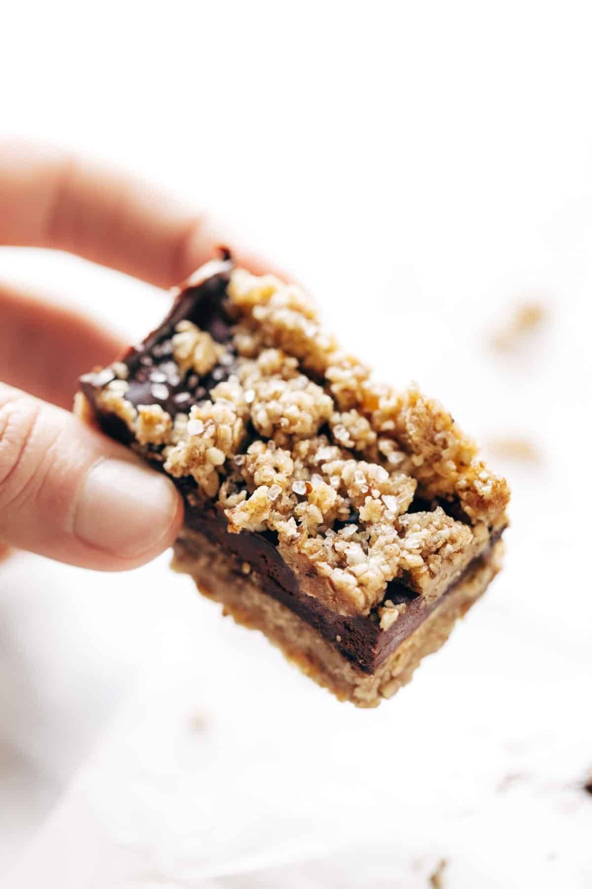 Salted chocolate snack bar held by hand.