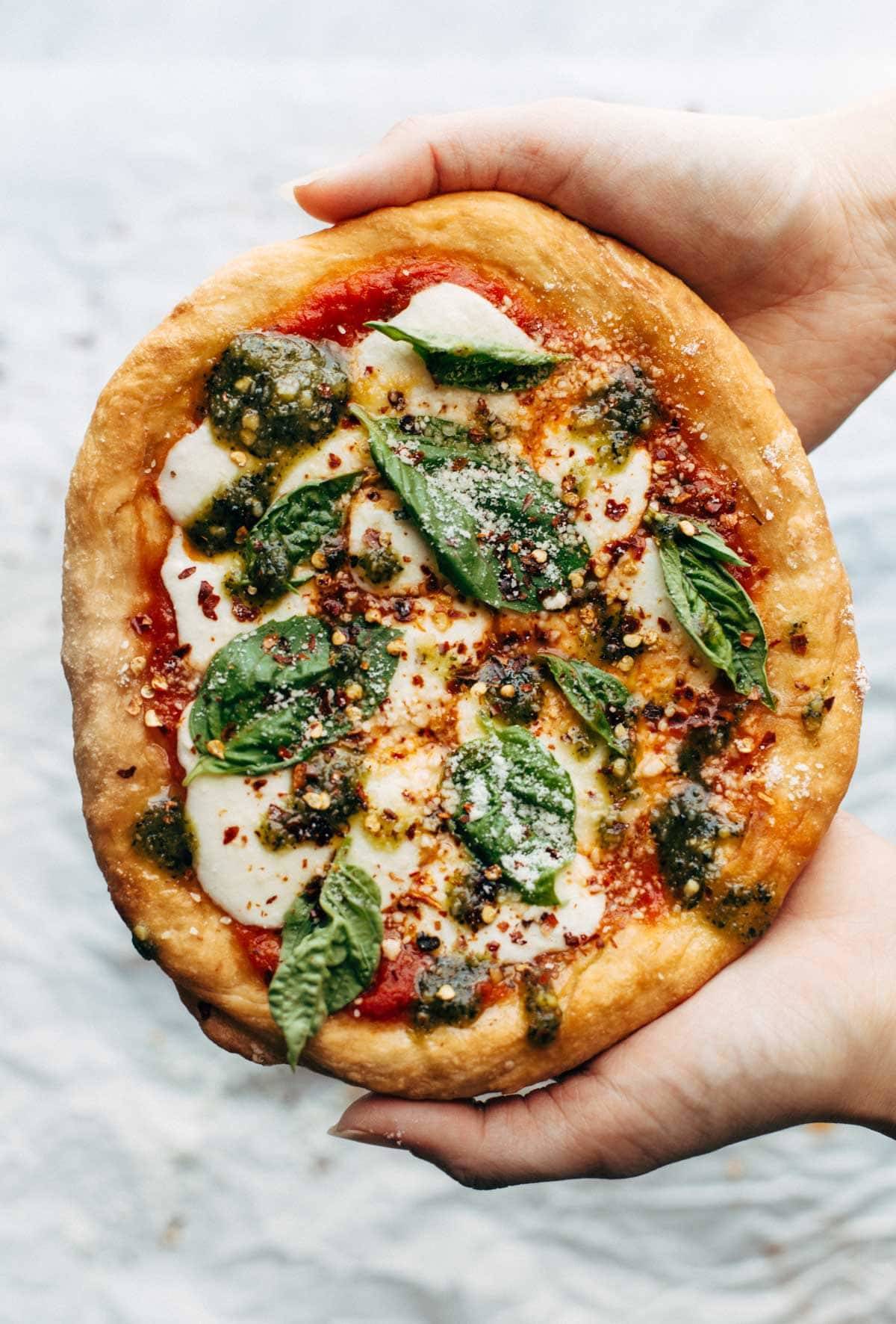 Fried pizza held by two hands.