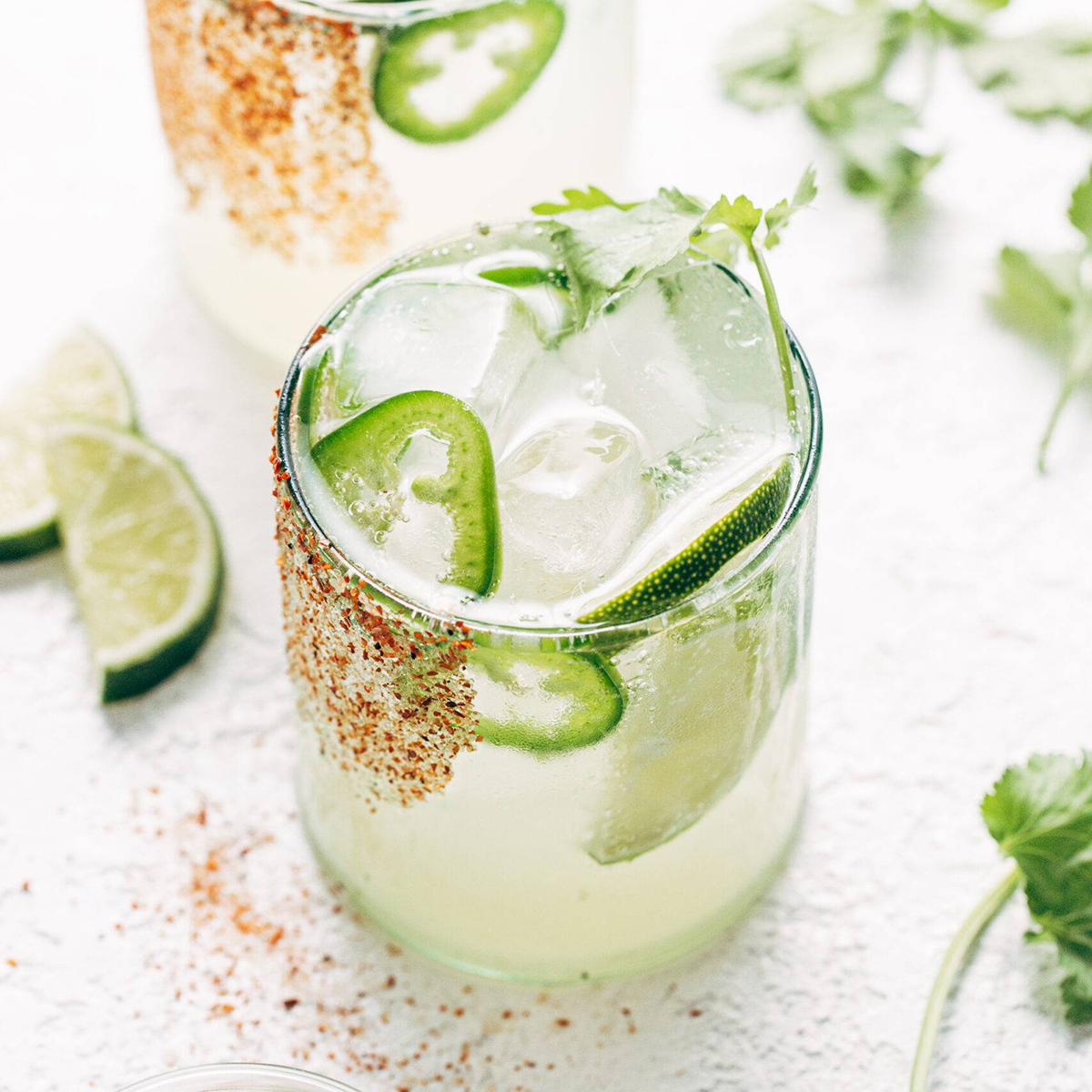 Non-alcoholic margarita in a glass with jalapeño and a salted rim.