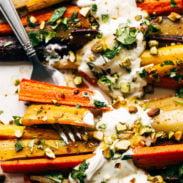 Roasted carrots on a pan with a fork.
