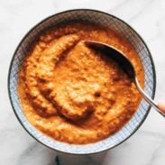 Romesco sauce in a bowl with a spoon.