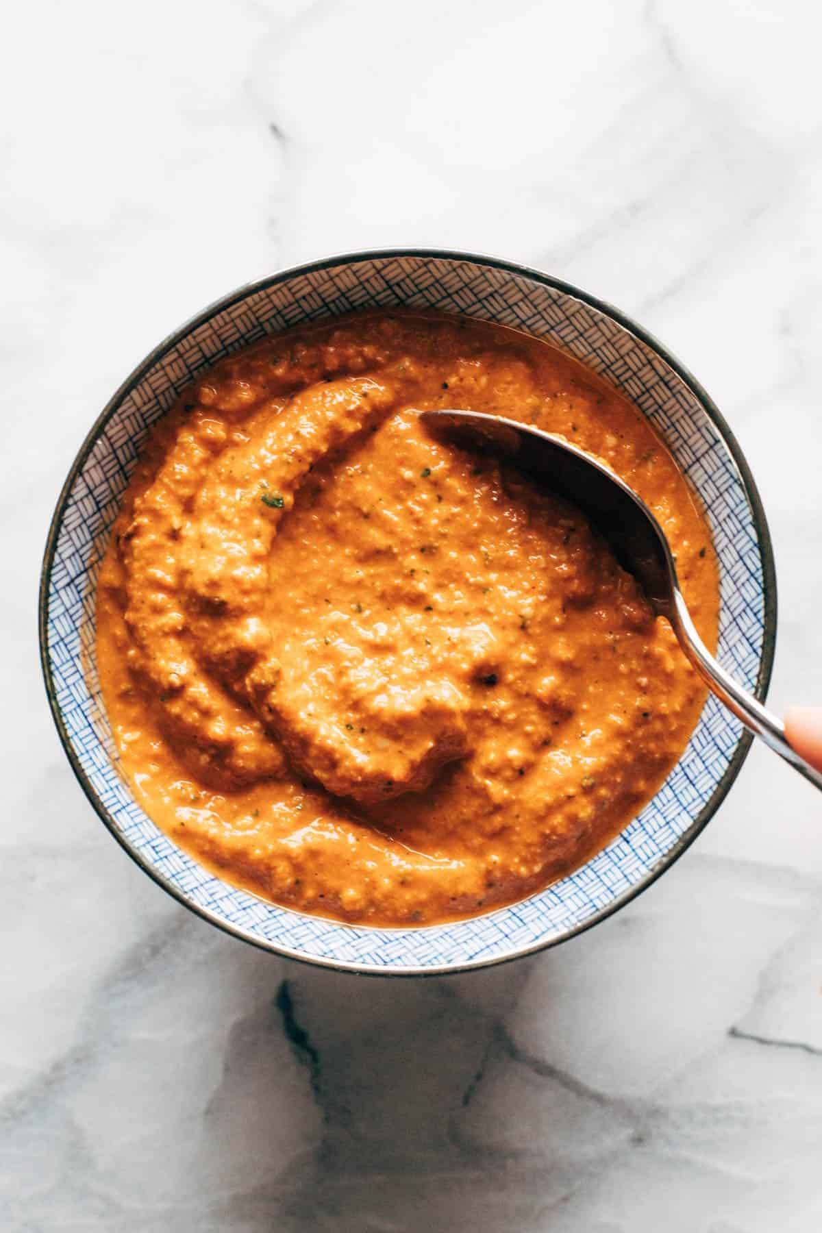 Romesco sauce in a bowl with a spoon.