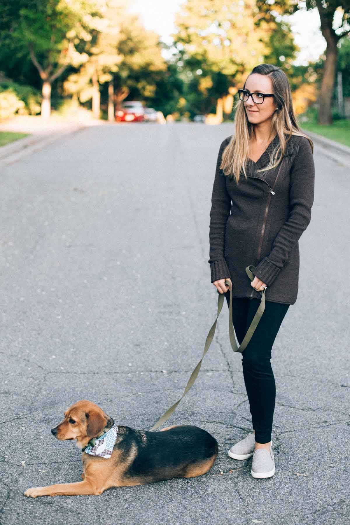 dog and woman standing on a road