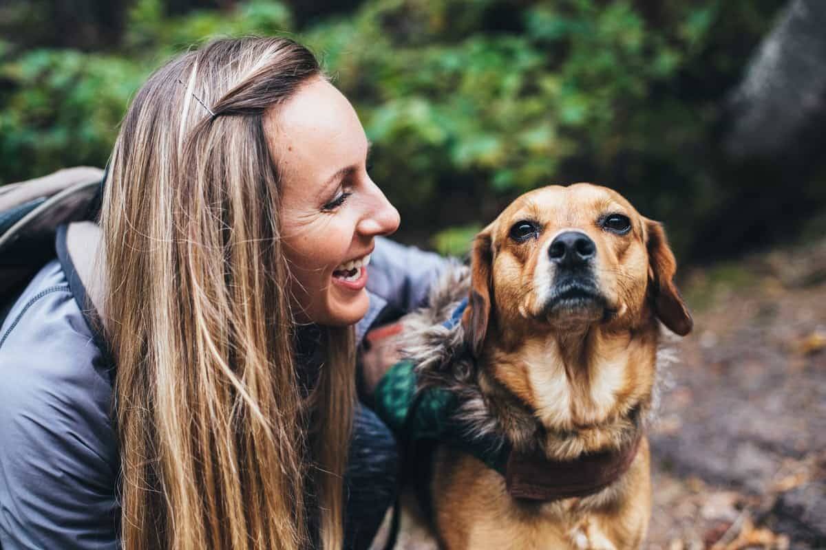 Woman laughing at a dog.